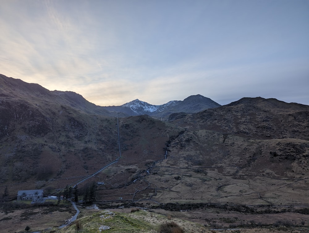 a view of a mountain range with a house in the foreground