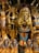 The image displays a collection of ornate Egyptian statues and artifacts featuring vibrant colors and intricate details. Prominent figures include pharaohs and deities adorned in gold, blue, and red.