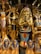 The image displays a collection of ornate Egyptian statues and artifacts featuring vibrant colors and intricate details. Prominent figures include pharaohs and deities adorned in gold, blue, and red.