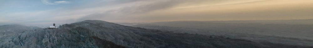 a very large mountain covered in snow under a cloudy sky