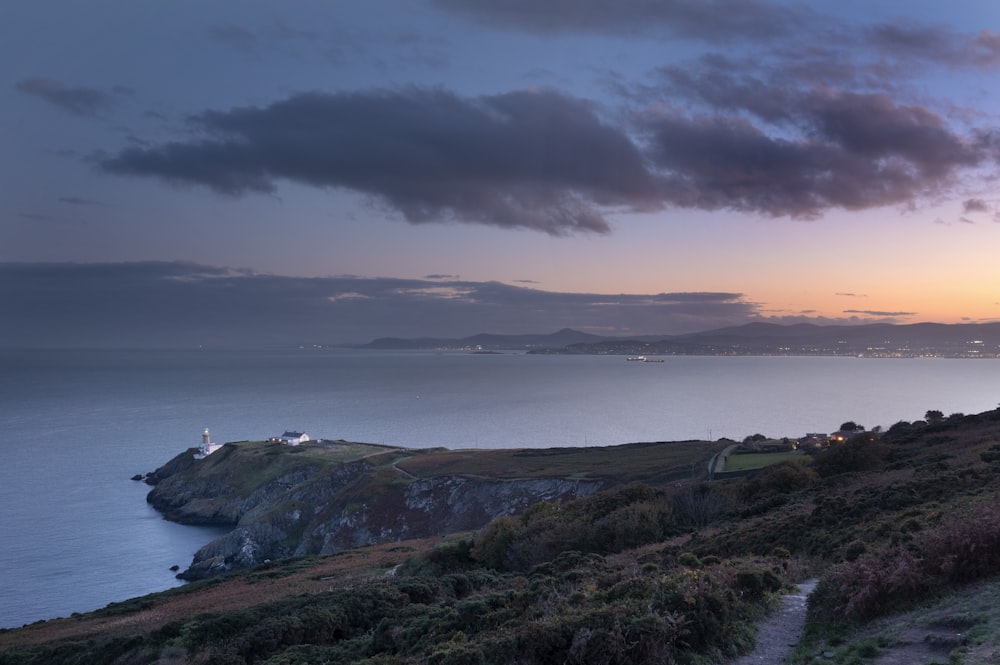 a path leading to a lighthouse on top of a hill