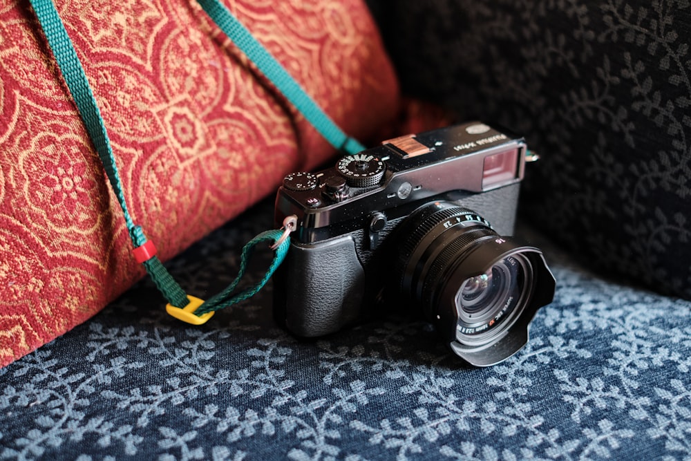 a camera sitting on top of a couch next to a pillow