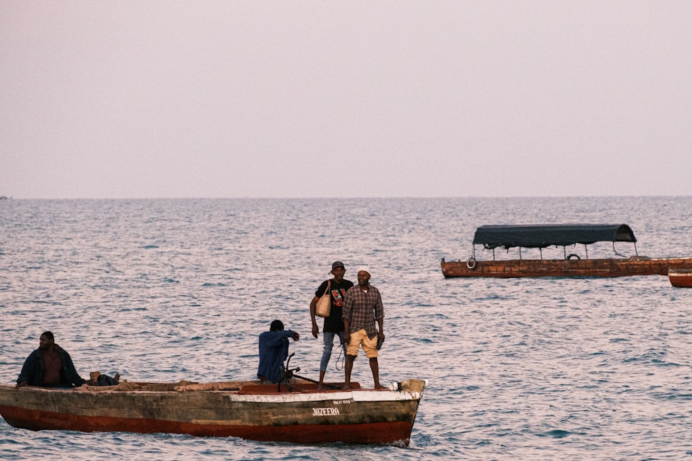 Un gruppo di uomini in piedi sulla cima di una barca nell'oceano