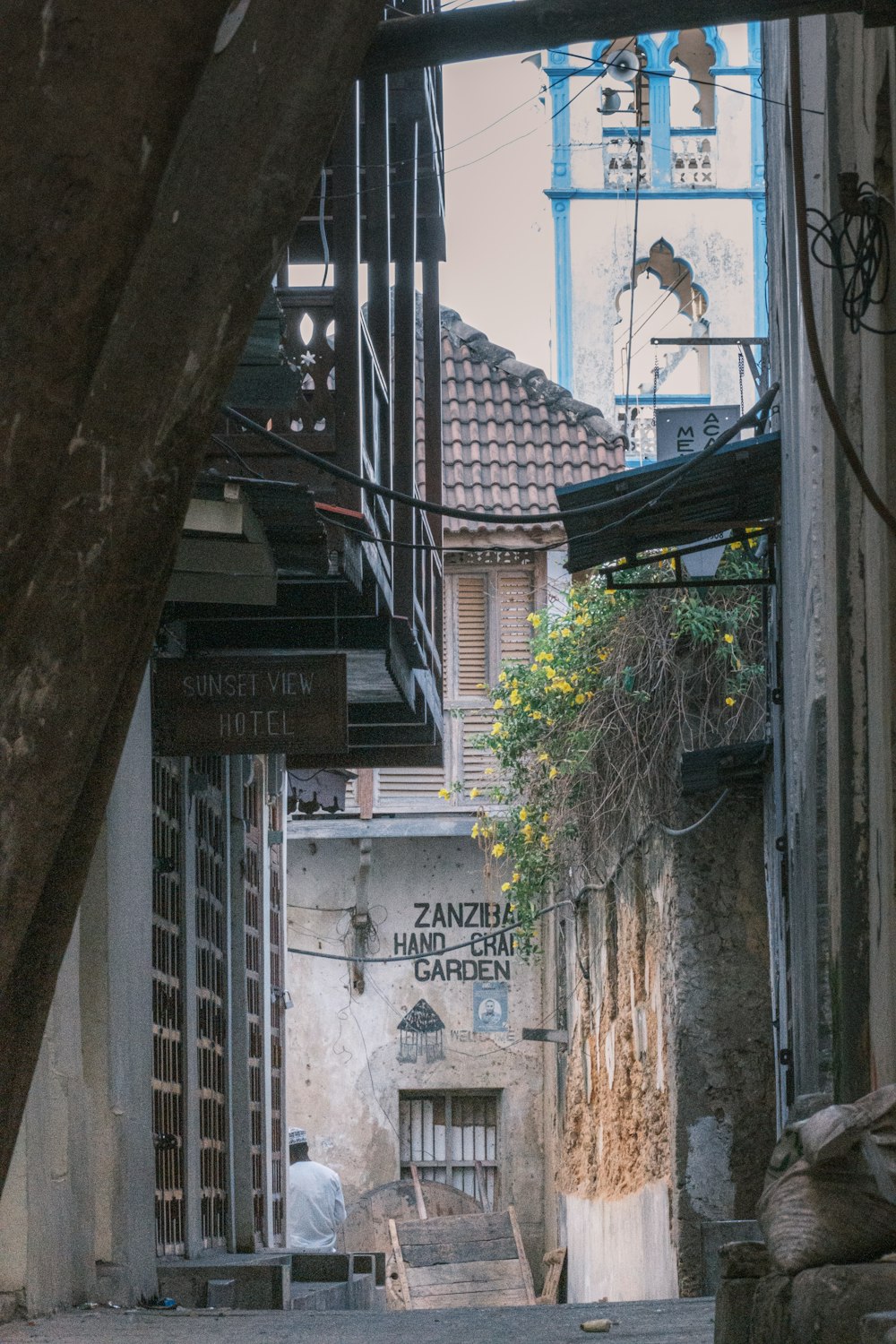 a narrow alley way with a clock tower in the background