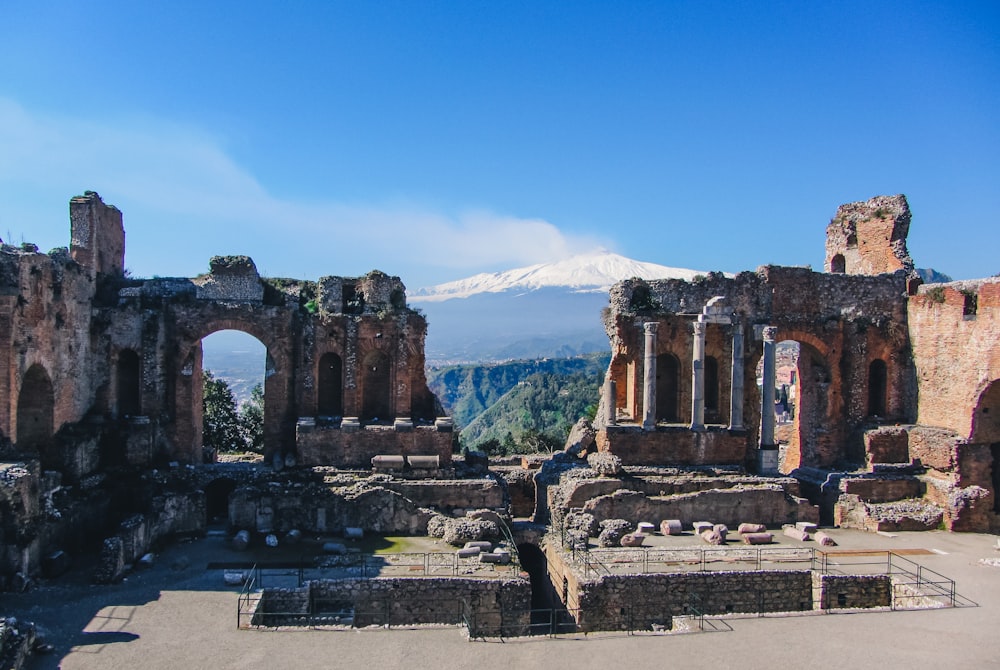 the ruins of a building with a mountain in the background