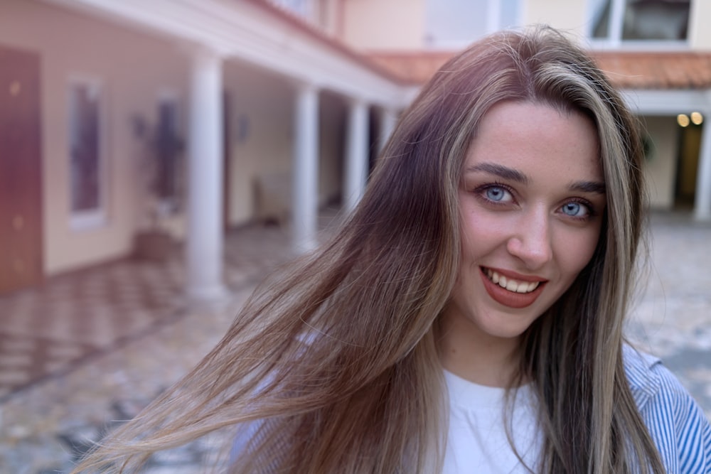 a woman with long hair is smiling for the camera