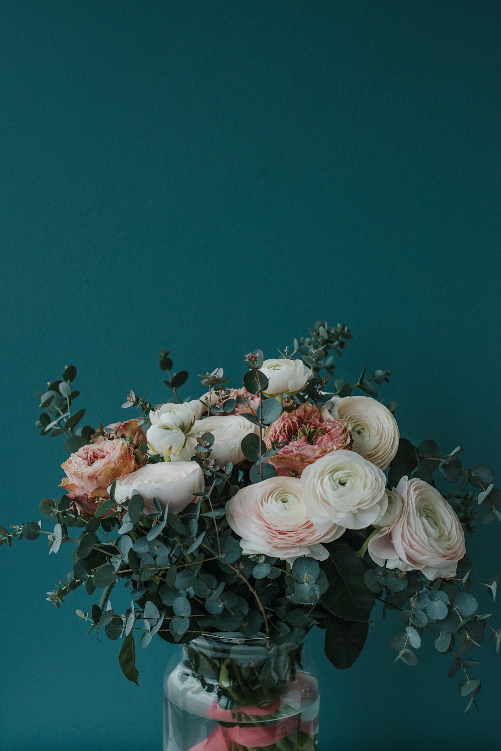 a vase filled with lots of flowers on top of a table