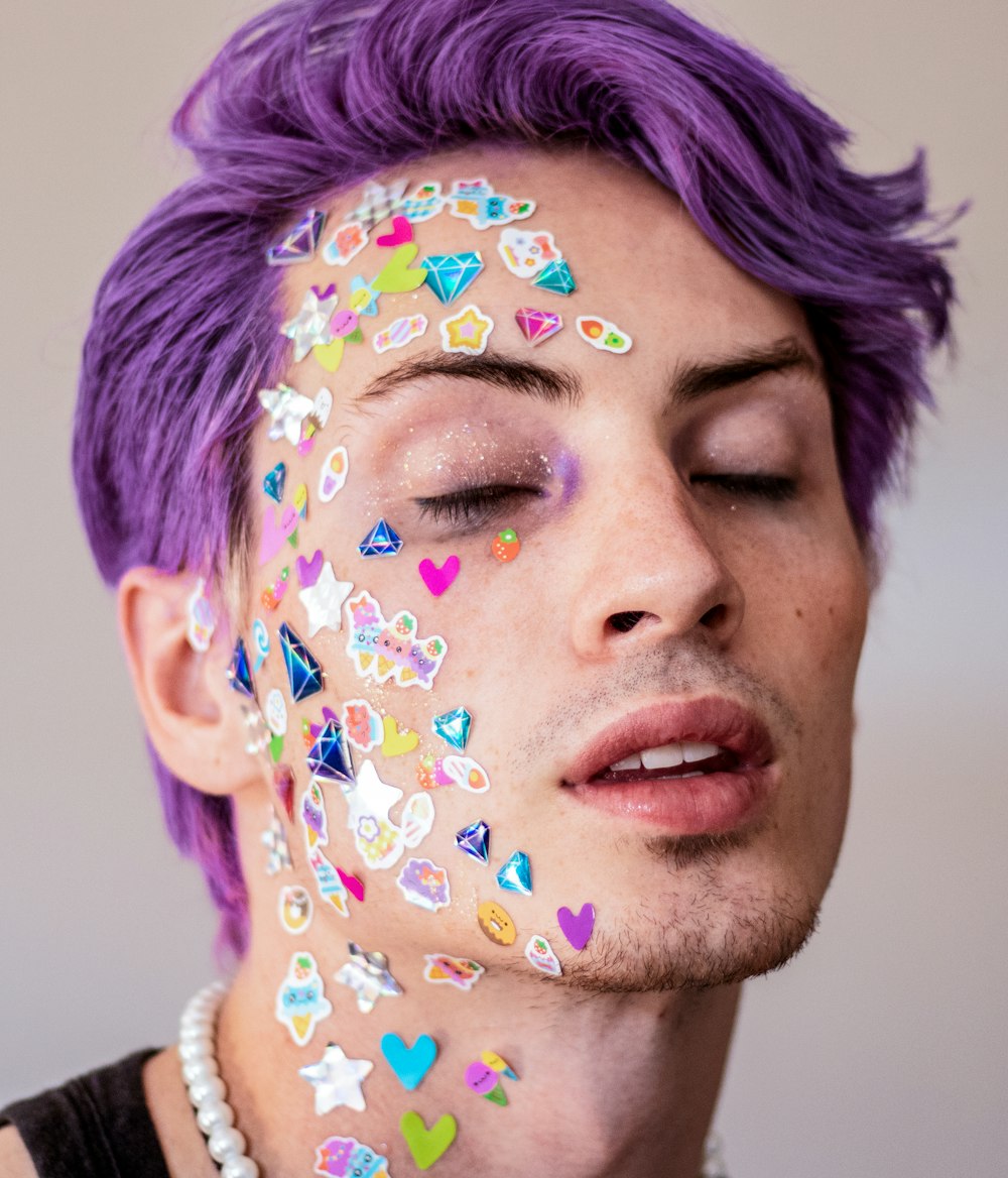 a man with purple hair and hearts painted on his face