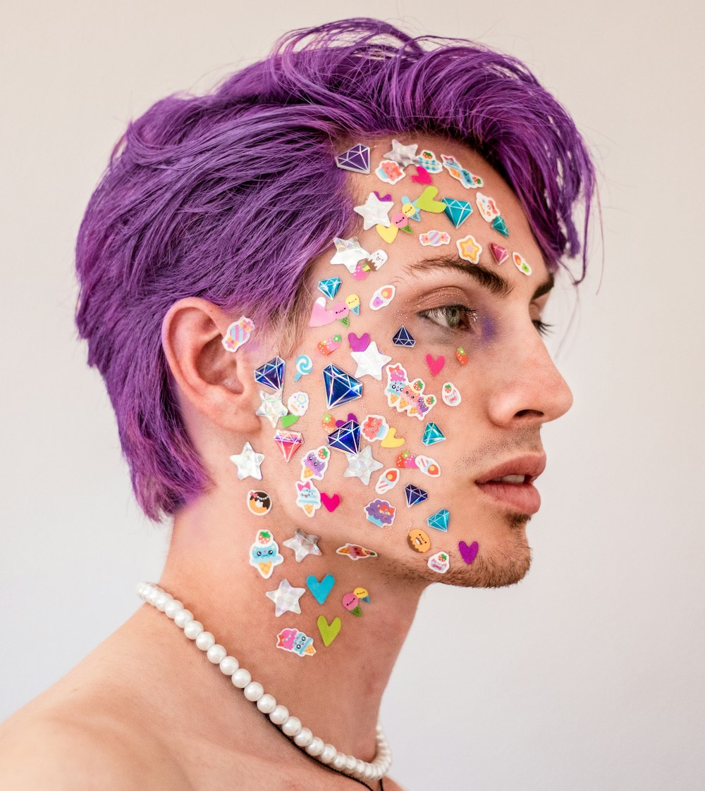 a man with purple hair and tattoos on his face