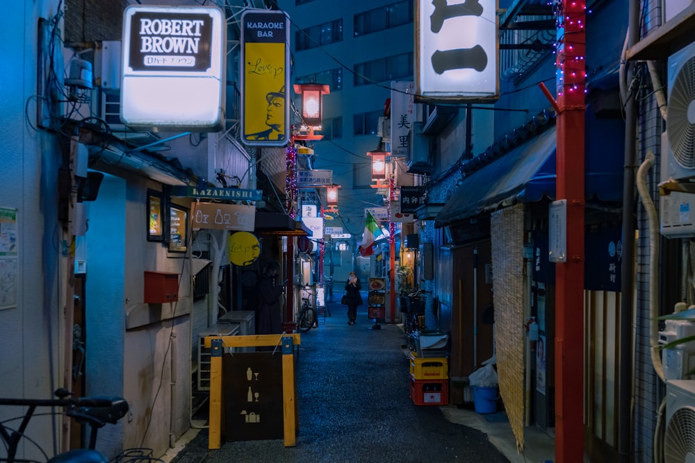 une ruelle étroite avec des panneaux et des lumières