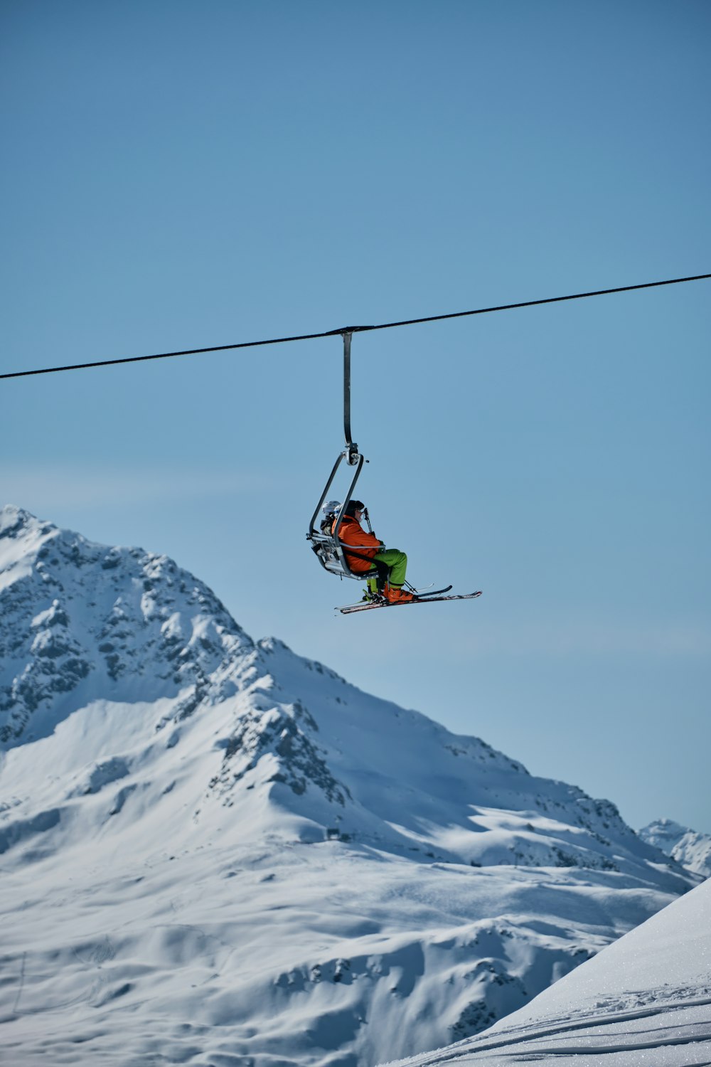 a person riding skis on top of a ski lift