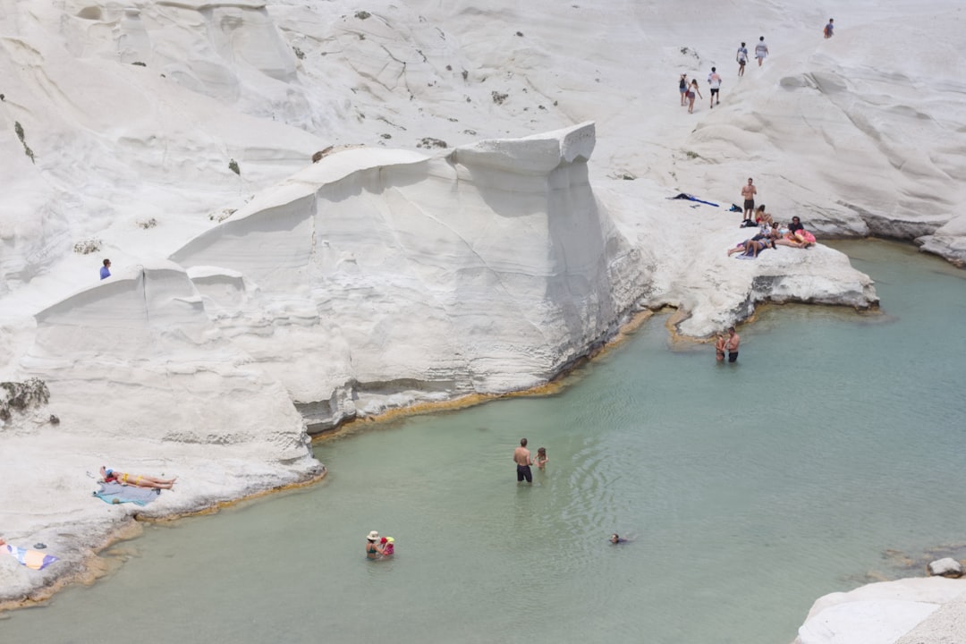 a group of people standing around a pool of water,