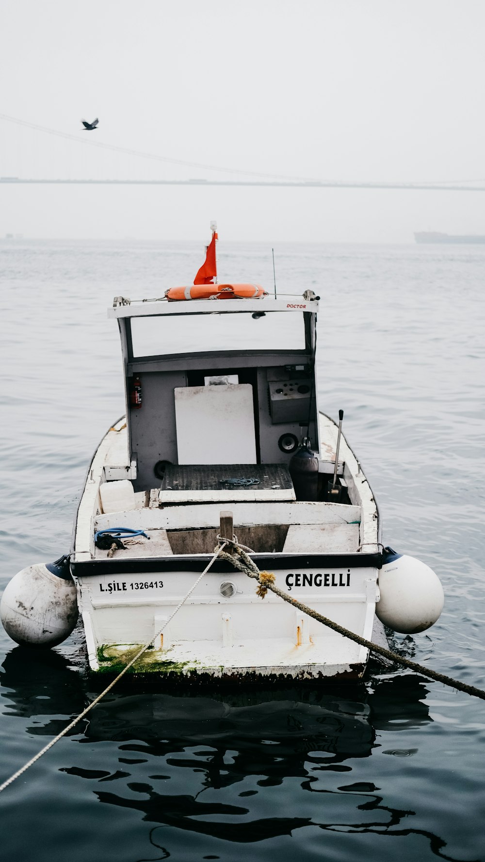 a small white boat floating on top of a body of water