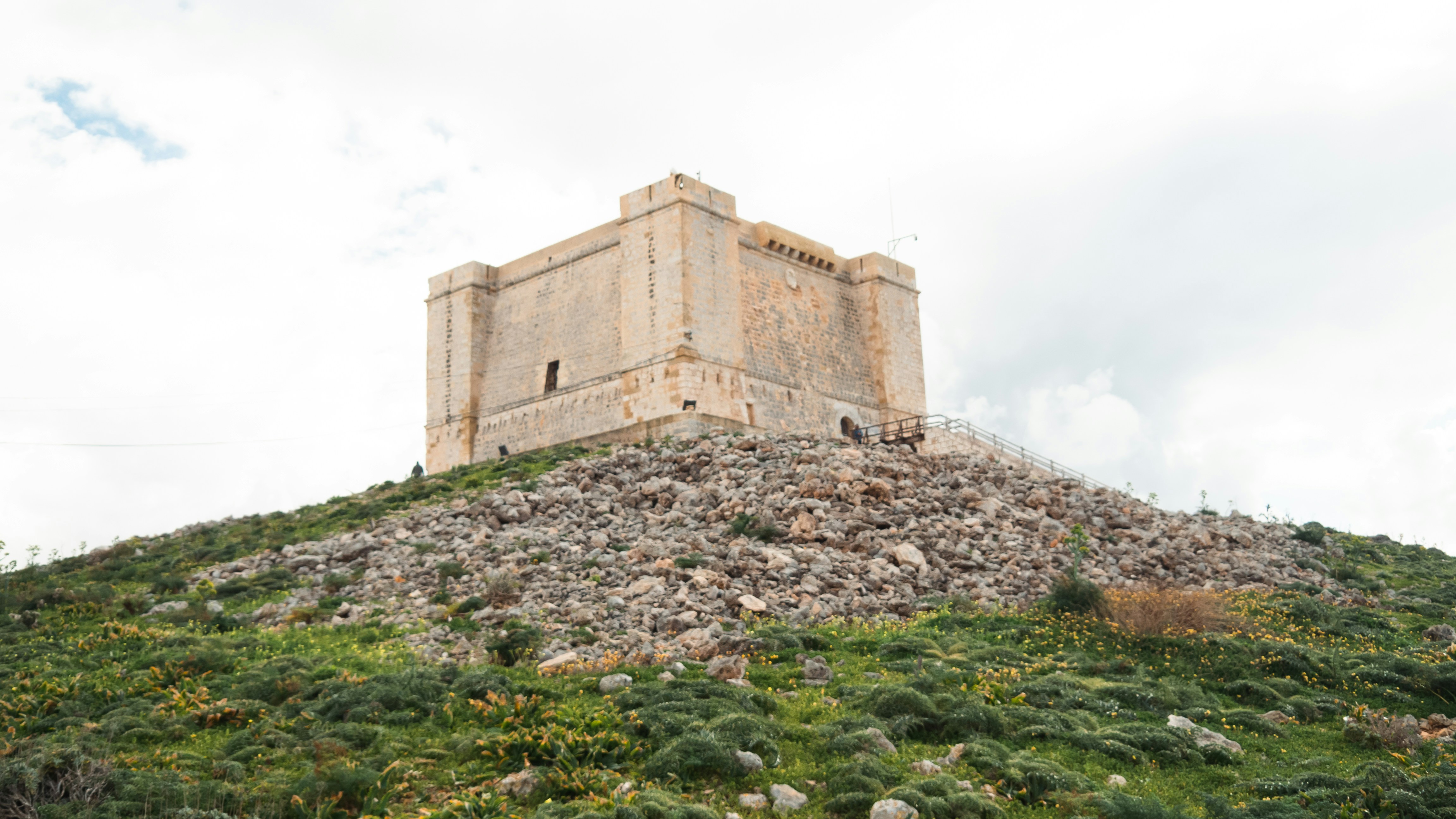 a very tall tower sitting on top of a lush green hillside