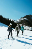 a group of people walking across a snow covered slope
