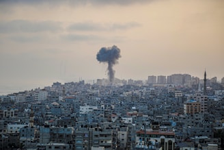 smoke billows from a factory in a city