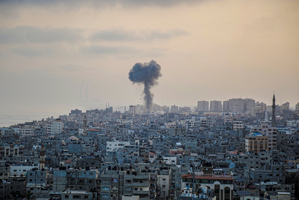 smoke billows from a factory in a city