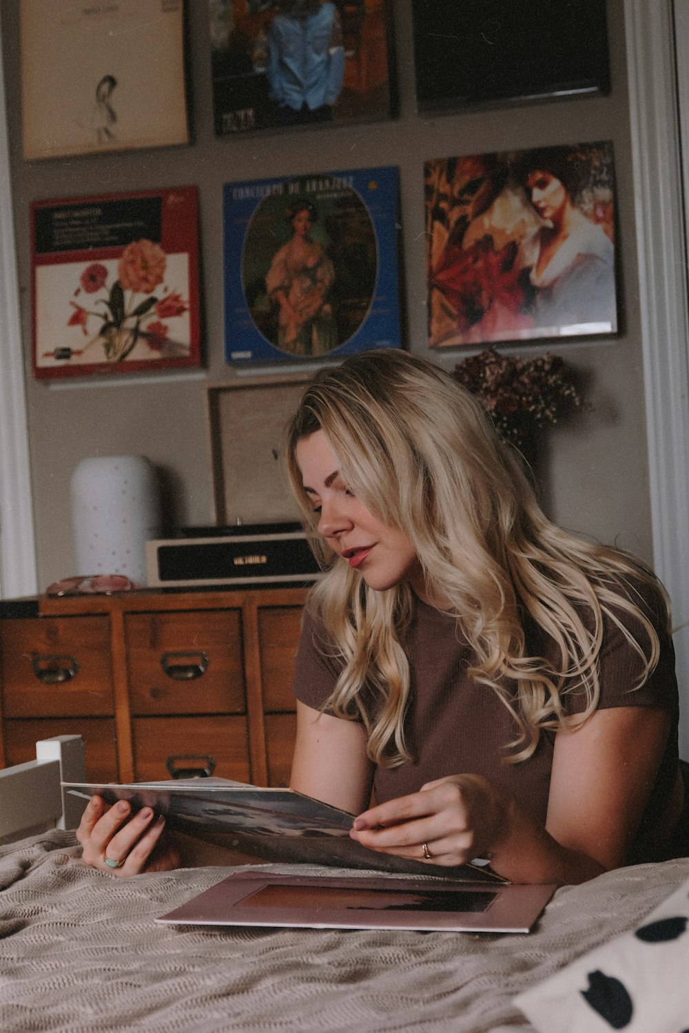 a woman sitting on a bed reading a book