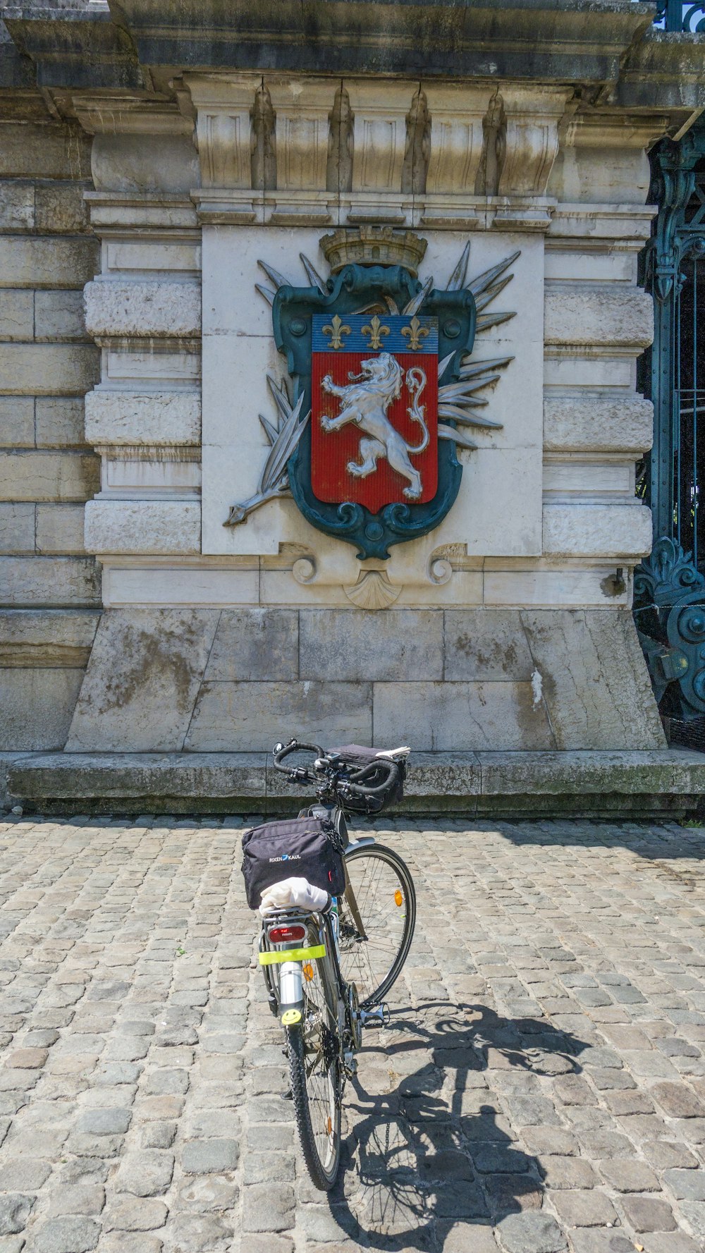 a bicycle parked in front of a building with a coat of arms on it