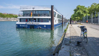 a blue and white boat docked next to a sidewalk