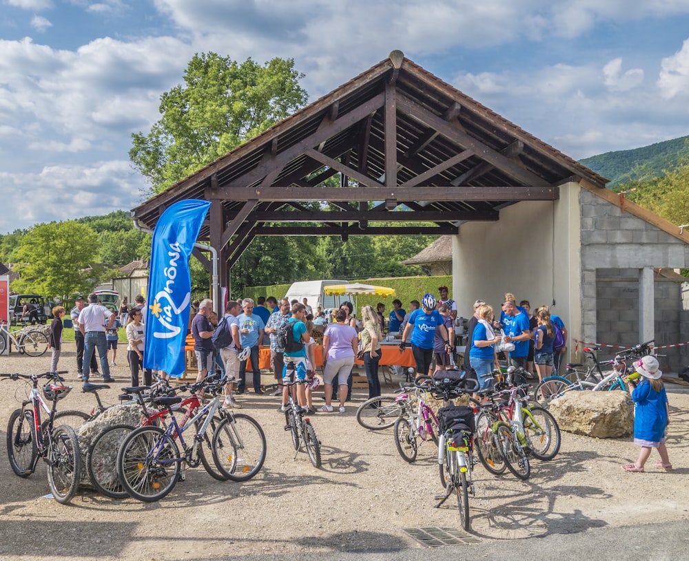 a group of people standing around a bunch of bikes