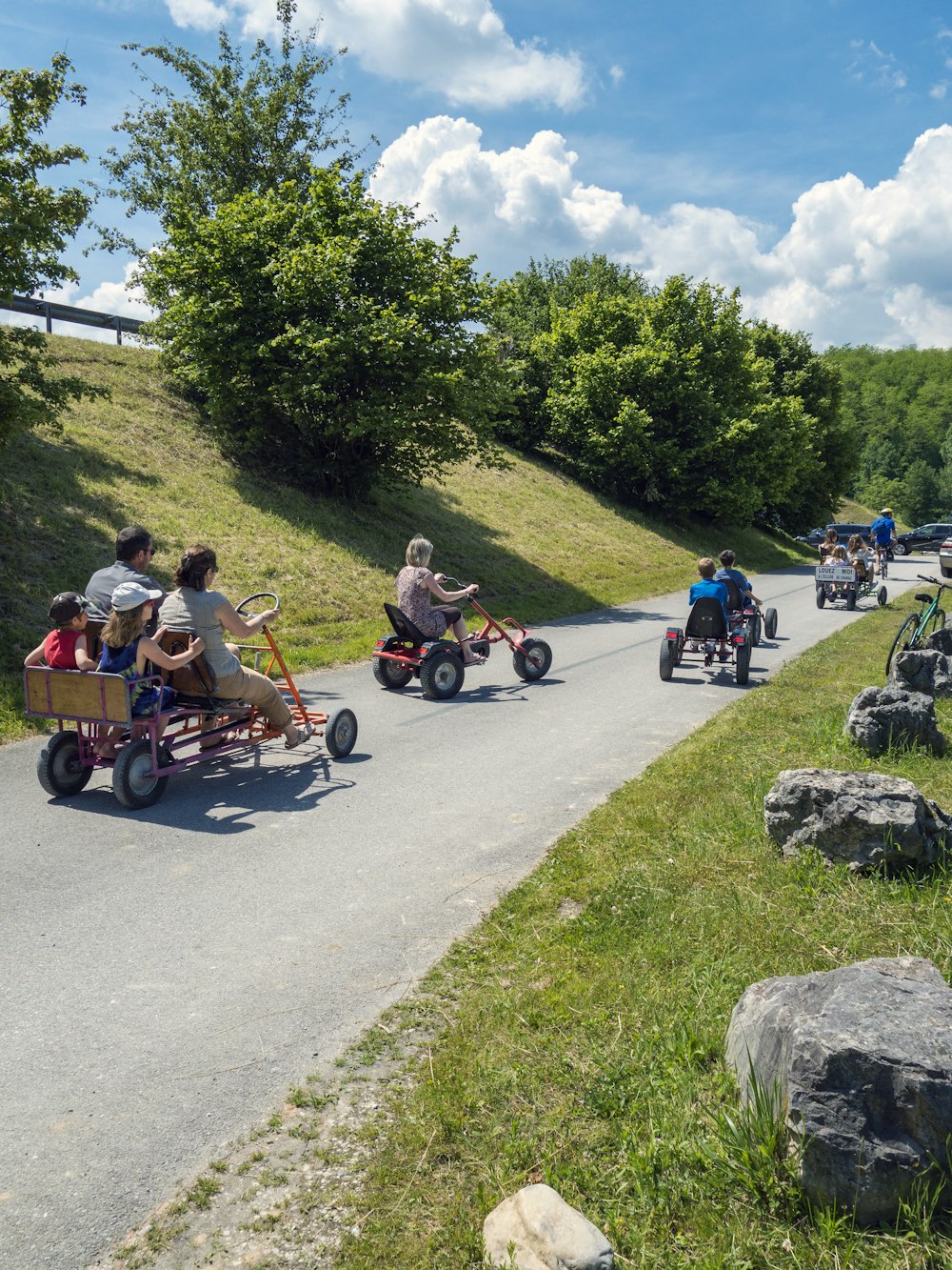 a group of people riding three wheeled vehicles down a road