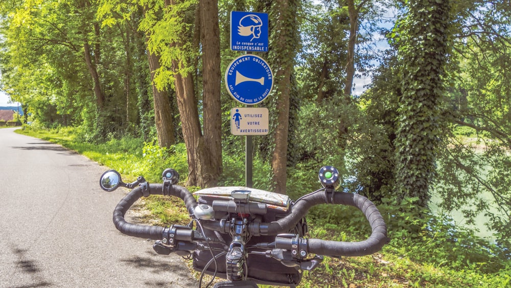 a motorcycle parked on the side of a road next to a forest