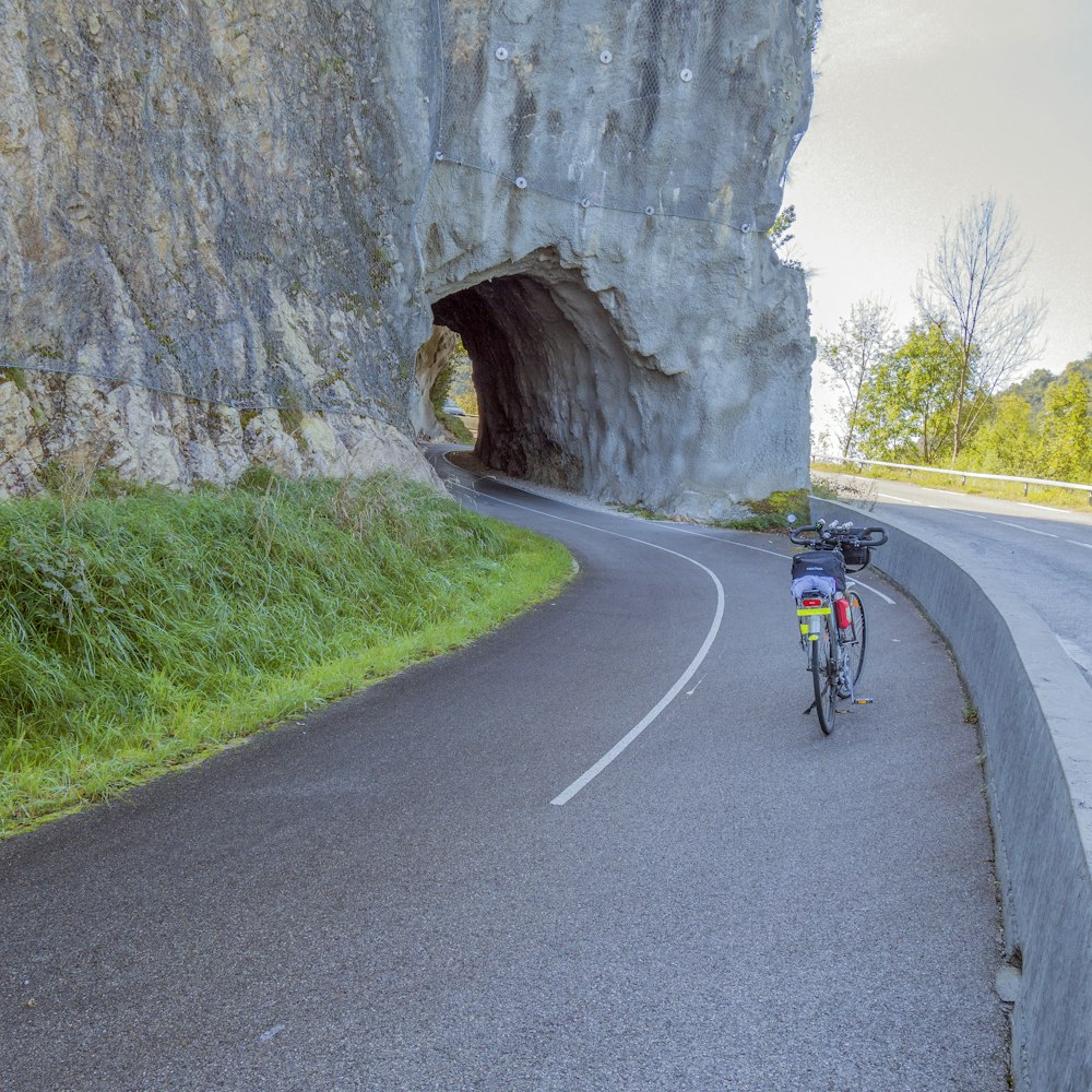 a man riding a bike down a curvy road