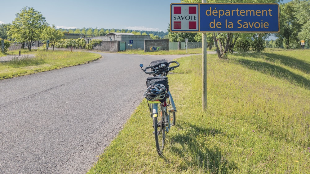 a bicycle parked next to a sign that says department de la savoie