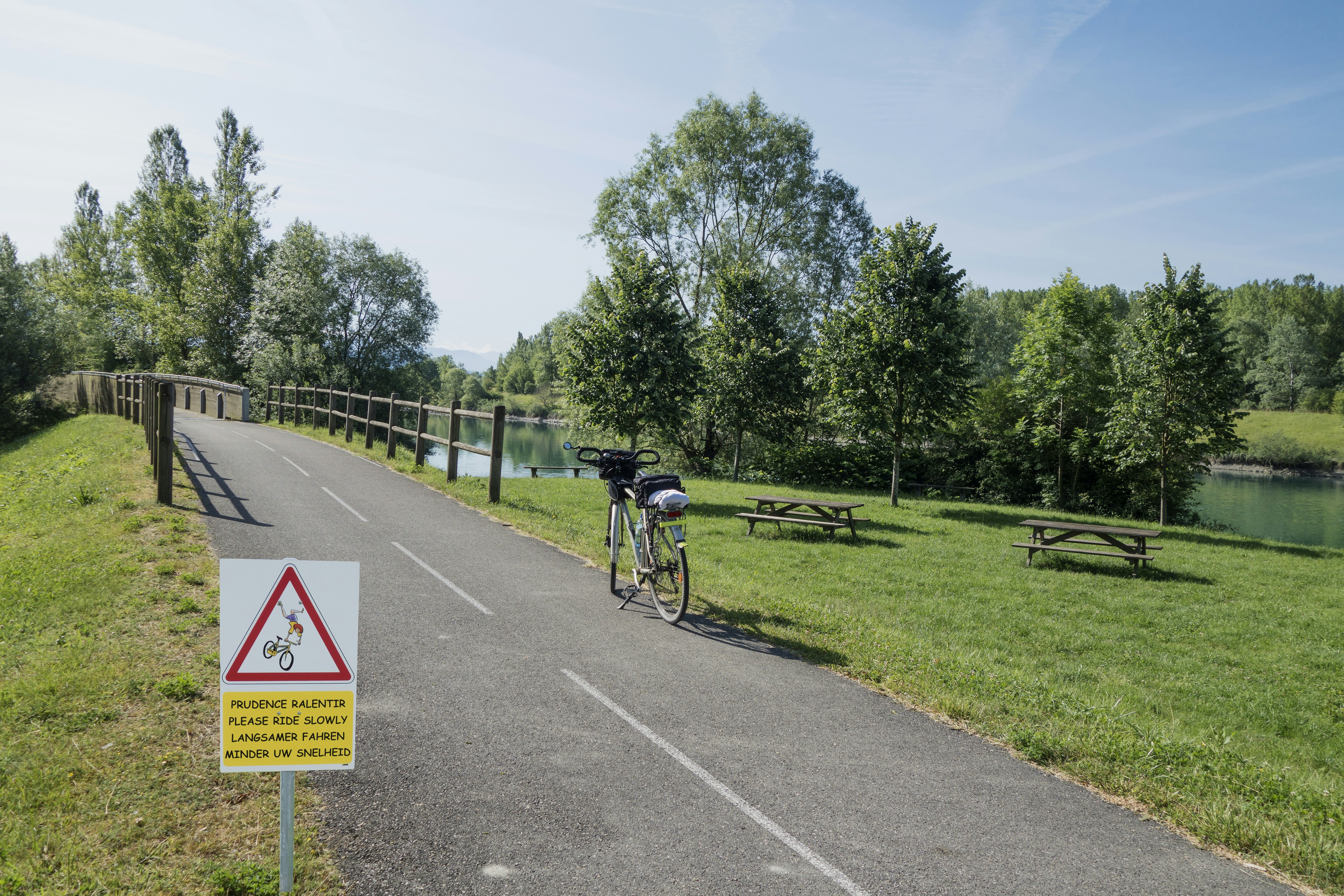 a bike parked on the side of a road next to a park
