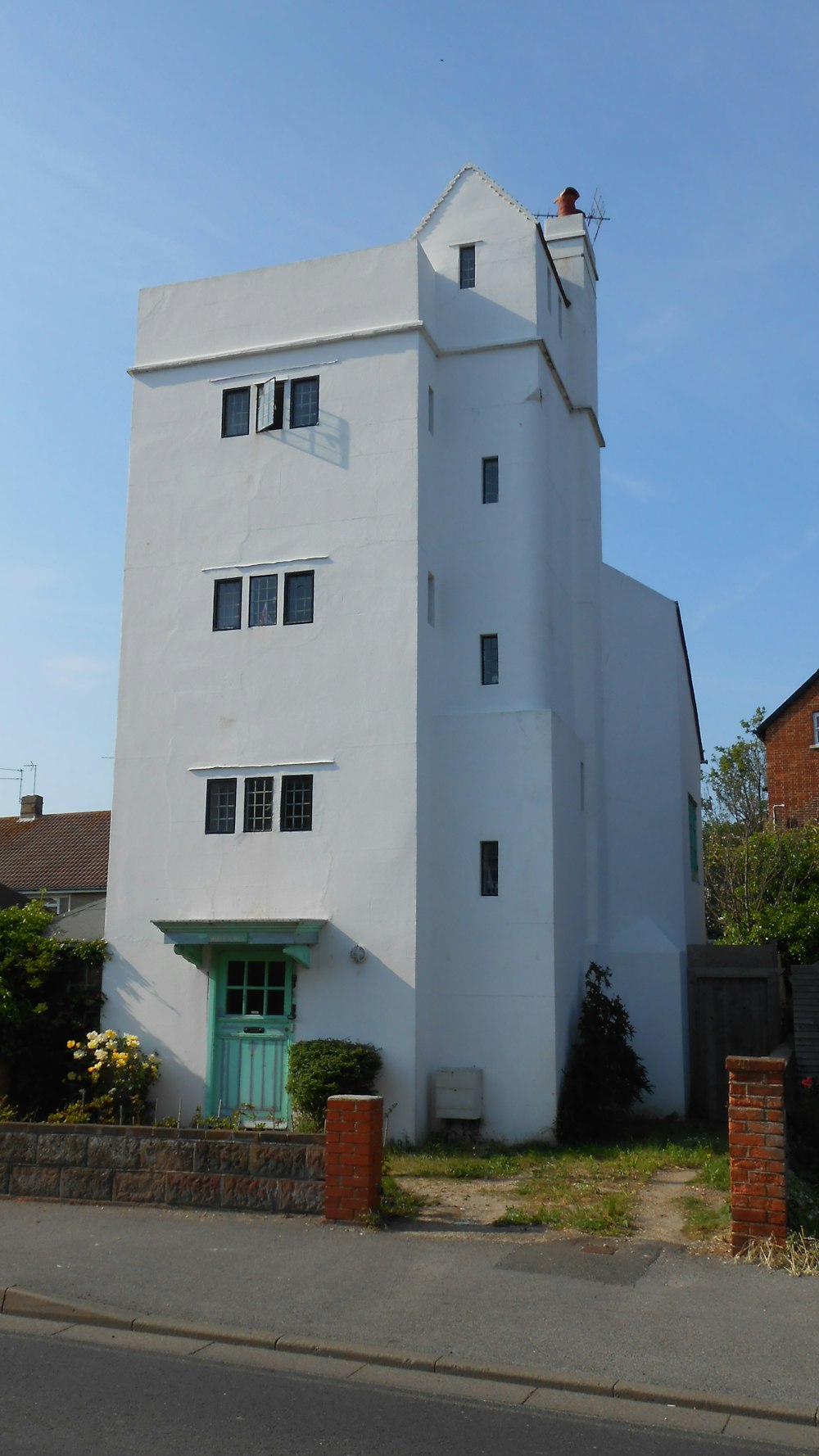 a tall white building with a green door