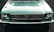 A front view of a vintage Ford Mustang with a teal color, featuring a distinctive grille and round headlights. The classic Mustang logo is prominently displayed at the center of the grille.