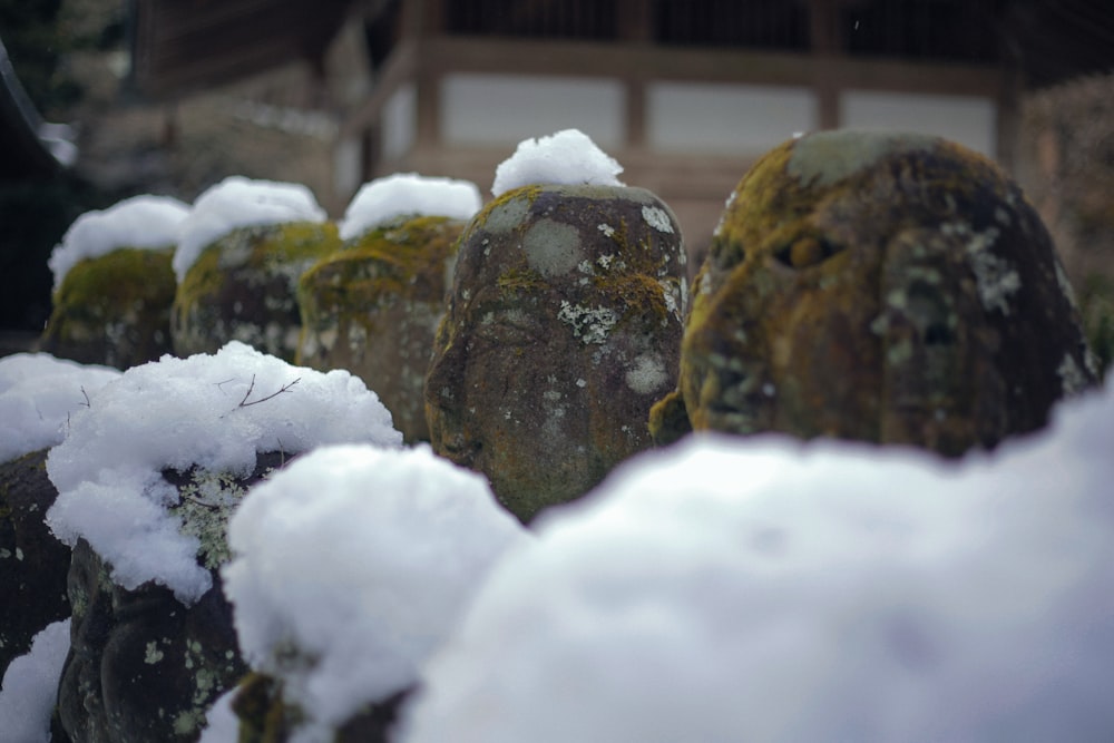 a group of statues covered in snow in front of a building