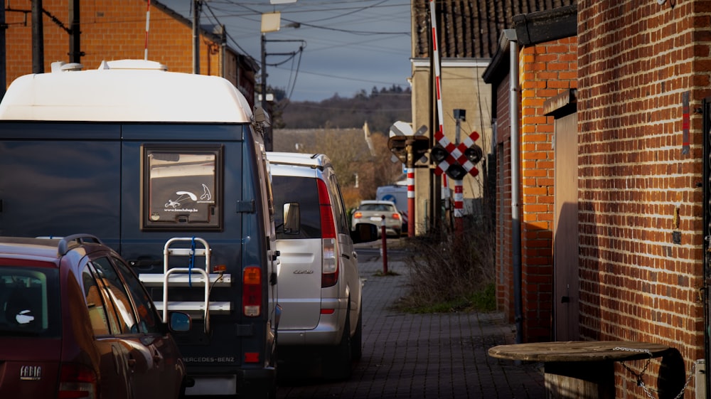 a van parked on the side of a road next to a brick building