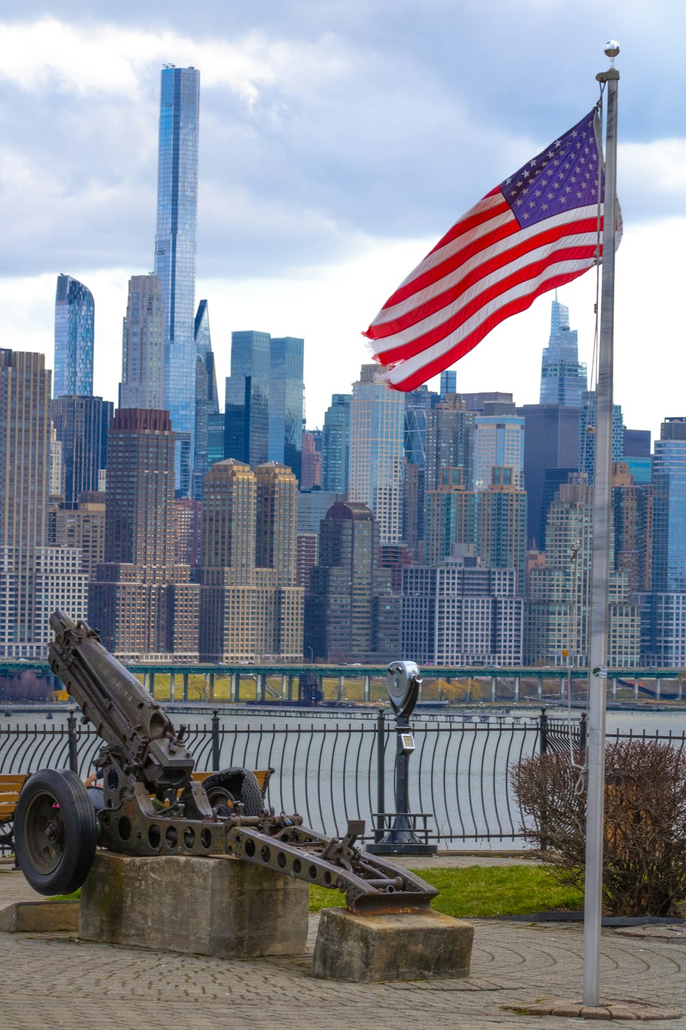 an american flag flying in front of a city skyline