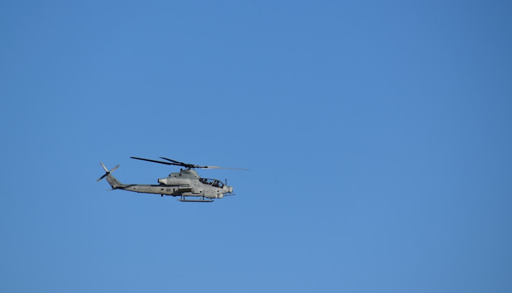 a helicopter flying through a blue sky on a sunny day