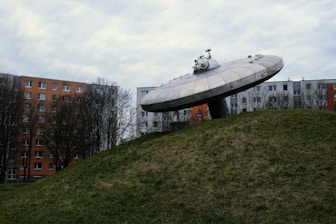 a large object sitting on top of a lush green hillside