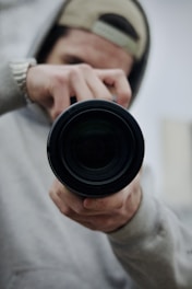 a man holding a camera lens in his hand