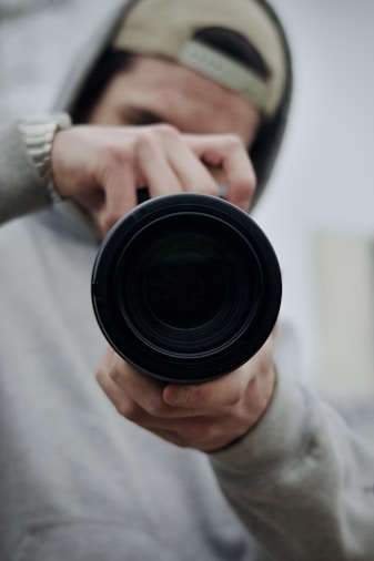 a man holding a camera lens in his hand