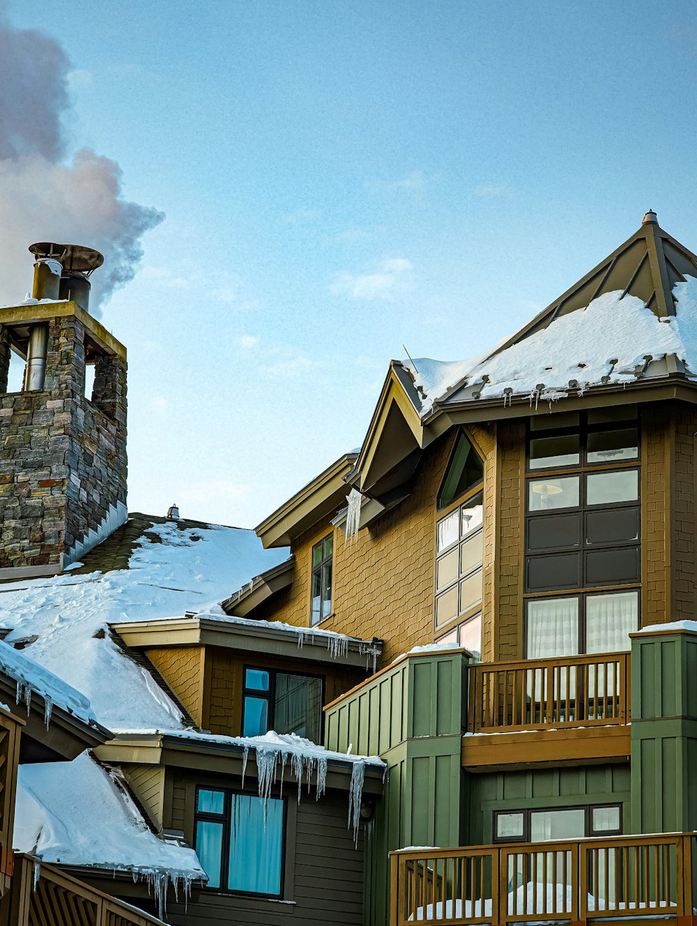 um edifício com neve no chão e uma torre do relógio ao fundo