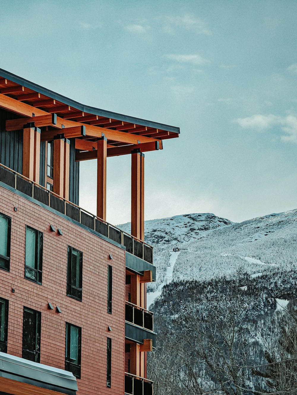 a red brick building with a snow covered mountain in the background