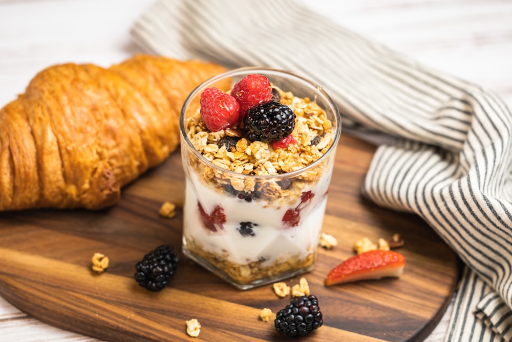 a glass of yogurt with berries and granola