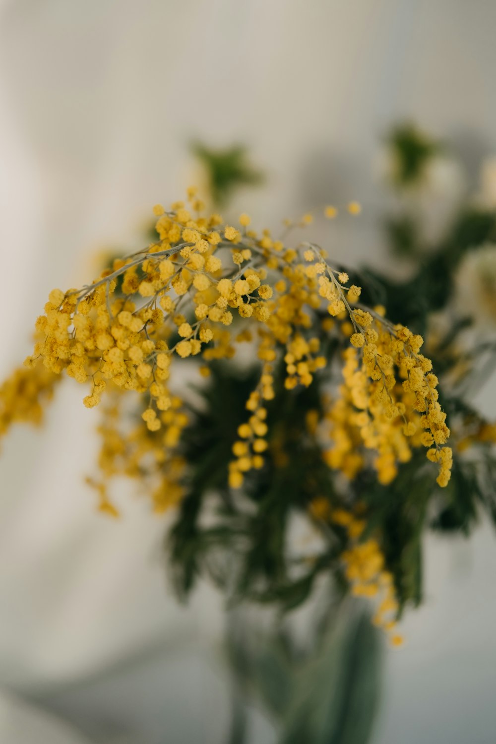 テーブルの上に黄色い花でいっぱいの花瓶