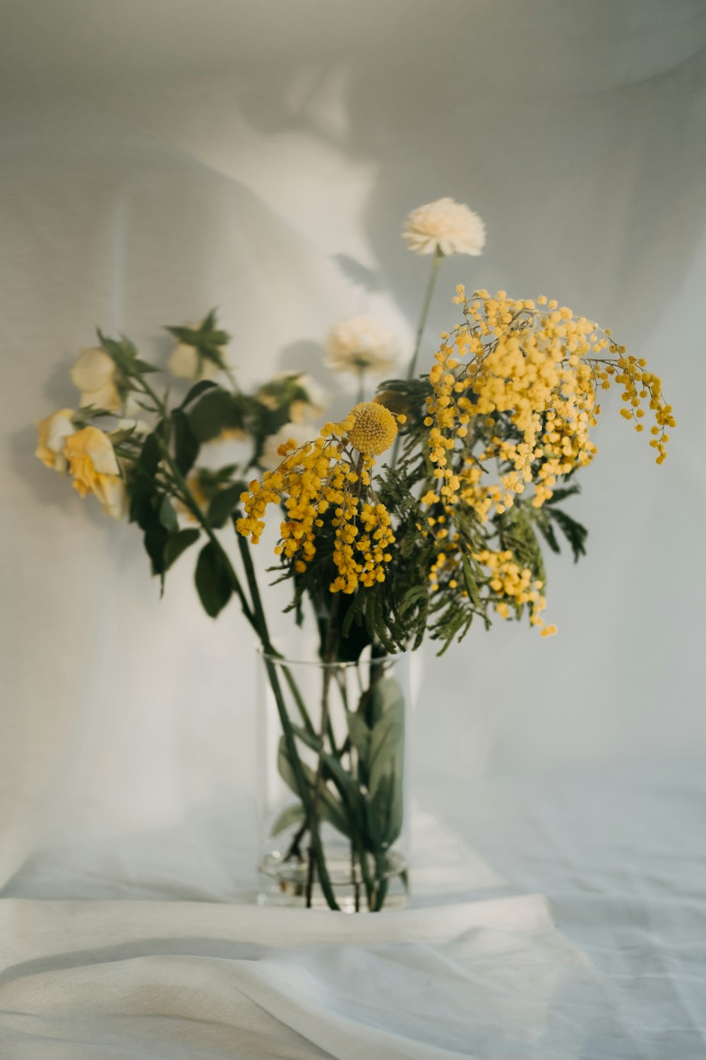 a vase filled with lots of yellow flowers