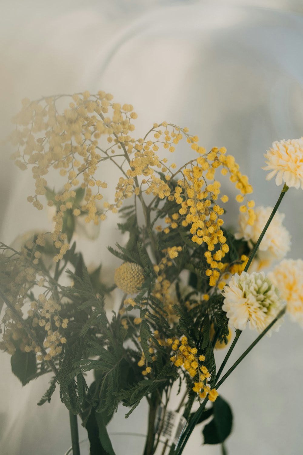 a vase filled with yellow and white flowers