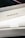 A close-up view of a MacBook Pro box, showcasing the sleek packaging design, primarily in white, with the words 'MacBook Pro' prominently displayed on the side. The image captures the clean lines and minimalistic style typical of Apple product packaging.