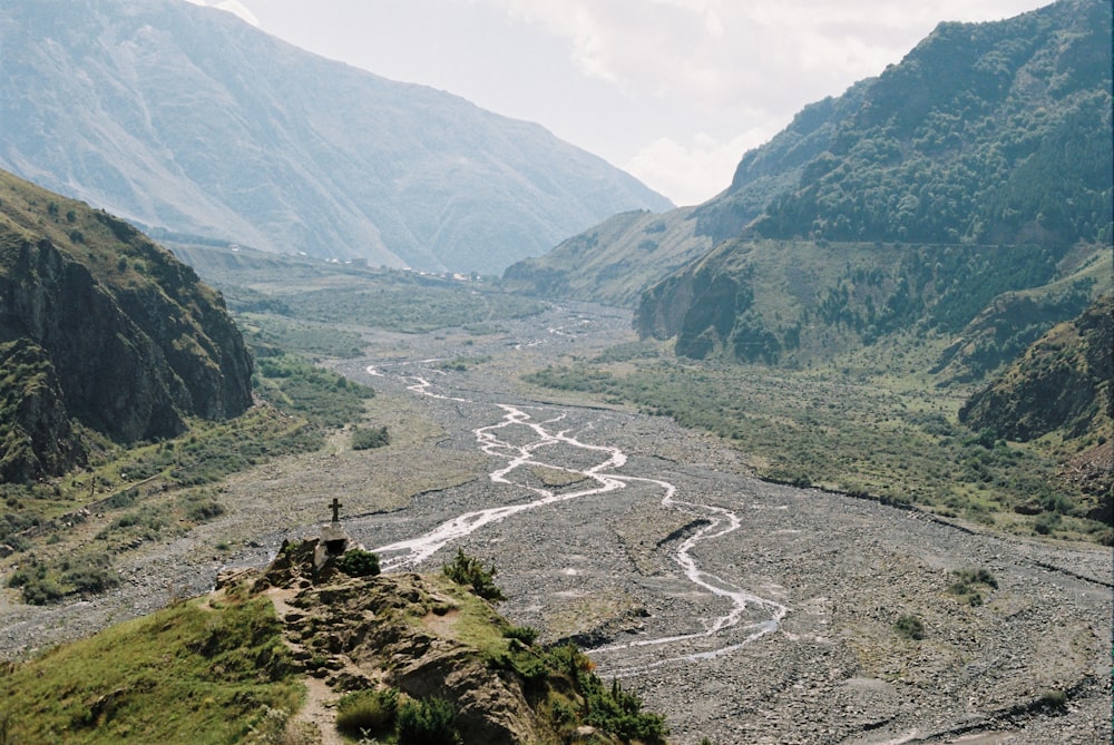 a river running through a valley surrounded by mountains