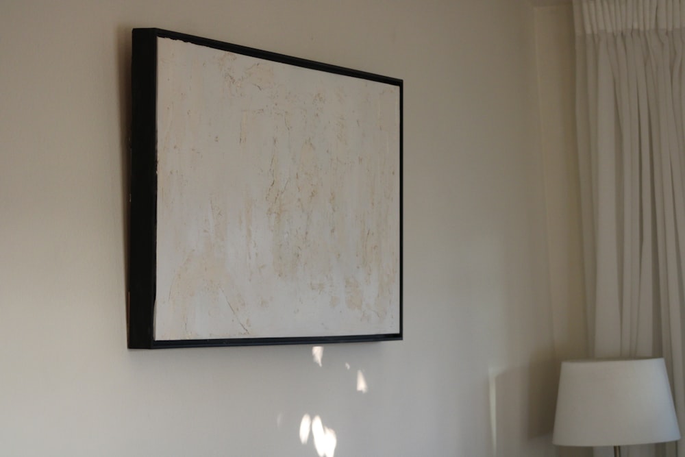 a painting hanging on a wall next to a lamp