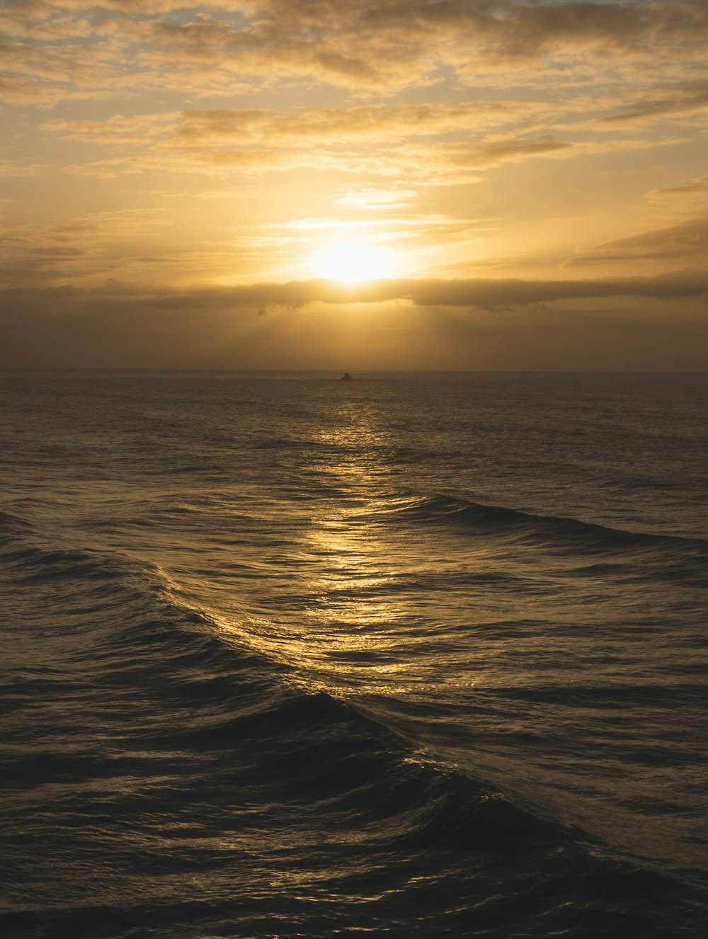 the sun is setting over the ocean with waves