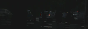 Emergency roadside assistance van parked beside a broken-down vehicle at dusk
